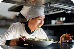 Close-up of Chef Olivia Sterling focused on intricate food preparation