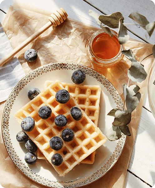 Blueberry waffles topped with syrup and fresh berries